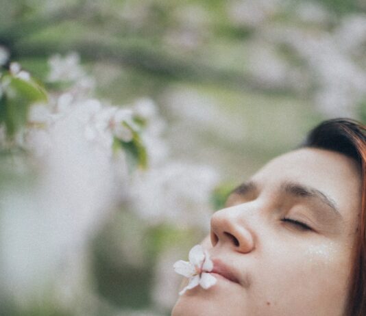 숨만 잘 쉬어도 인생이 바뀐다, 의식적인 호흡 수련 a woman with her eyes closed and a flower in her mouth
