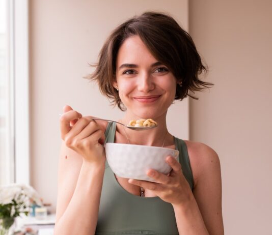 바쁜 직장인을 위한 건강관리, 작은 변화가 큰 차이를 만든다 a woman in a sports bra top holding a bowl of food