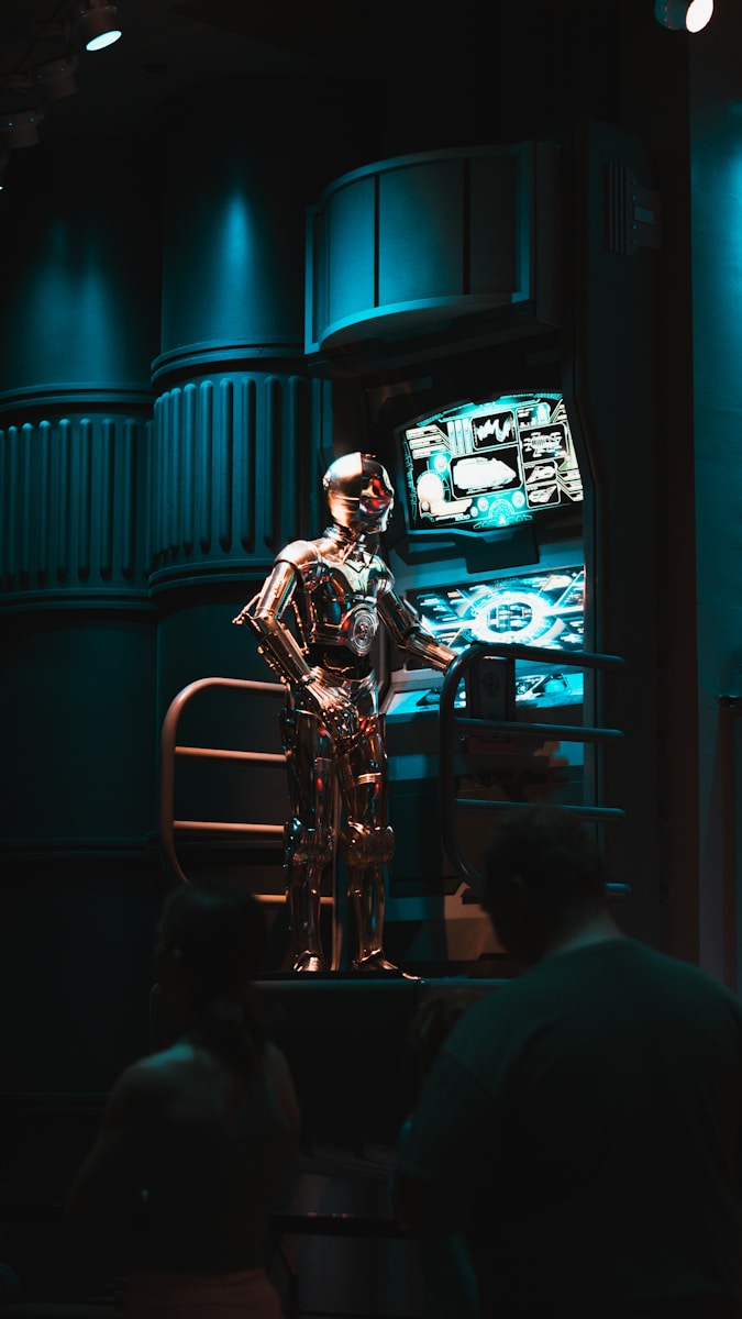 Photo by Nicholas Fuentes a man standing in front of a tv in a dark room