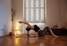 일상 속 활력 불어넣는 필라테스, 집과 직장에서 실천하는 건강 루틴 A woman is doing a yoga pose on a mat