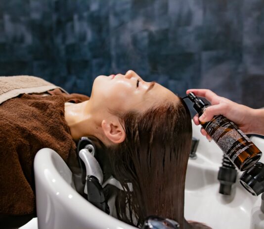 “내 머리결, 내가 지킨다”… 건강한 헤어 케어, 일상에서 시작하세요 a woman getting her hair washed in a sink