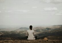 나만의 아침 루틴, 작은 변화로 건강과 활력을 채우다 woman sitting on cliff overlooking mountains during daytime
