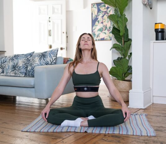 “마음 챙김 명상이 일상 속 스트레스를 누그러뜨린다…쉽게 시작하는 실천법은?” a woman sitting on a yoga mat in a living room