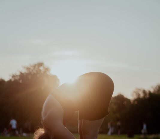 “건강하게 하루를 시작하는 작은 변화, 아침 스트레칭이 주는 선물” woman in white bikini bottom kneeling on green grass field during sunset