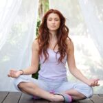 집에서 쉽게 실천하는 ‘마음 챙김’…일상 속 스트레스 관리법 주목 woman doing yoga pose sitting on wooden ground
