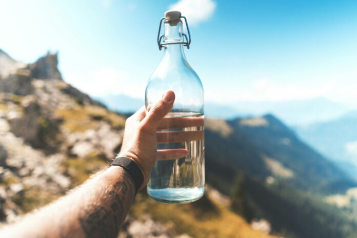 Photo by Marvin Meyer person holding empty clear glass bottle